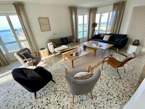 un salon avec un canapé, des chaises et une table dans l'établissement La Terrasse du Port - Front de Mer - 10 Personnes, à Port-en-Bessin-Huppain