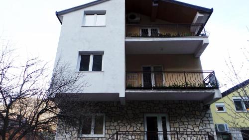 a tall white building with a balcony at Apartment Katica Mostar in Mostar