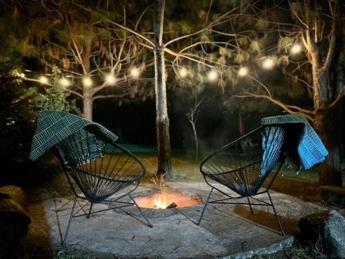 zwei Stühle, die nachts vor einem Feuer sitzen in der Unterkunft Casa monarca in Toluca de Lerdo