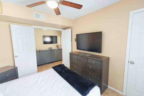 a bedroom with a bed and a flat screen tv at The Cool Cactus Condo with Pool and Jacuzzi in Tempe