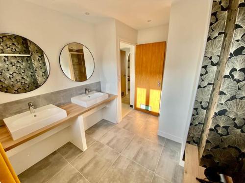 uma casa de banho com dois lavatórios e dois espelhos em La Terrasse du Port - Front de Mer - 10 Personnes em Port-en-Bessin-Huppain