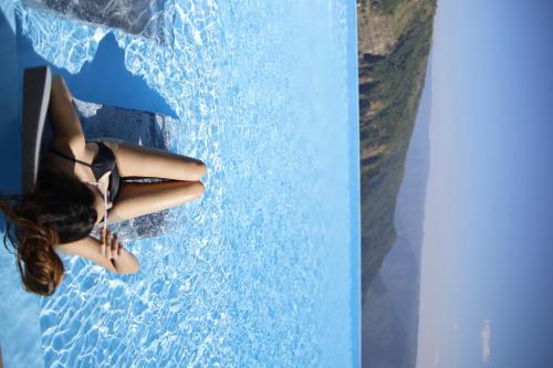 a woman sitting in the water in a swimming pool at Polo Cherrapunjee Resort in Cherrapunji