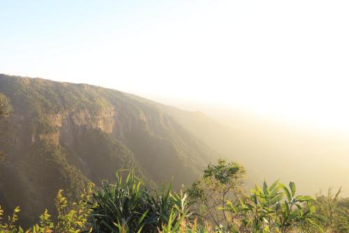 a view of a mountain with the ocean in the background at Polo Orchid Resort Cherrapunjee in Cherrapunji