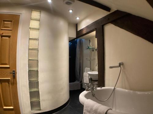uma casa de banho com uma banheira e um lavatório em Amazing 2BD Apartment -Upper floors of Dufton Hall em Dufton