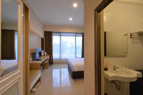 a hotel room with a bed and a sink at Hotel Sindha in Ruteng