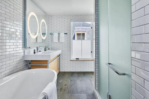 Un baño blanco con bañera y lavabo. en Downtown Aspen Luxury 3 Bedroom Residence, en Aspen