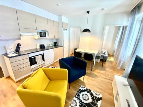 ヴァーサにあるDP Apartments Vaasaのリビングルーム(黄色い椅子付)、キッチン