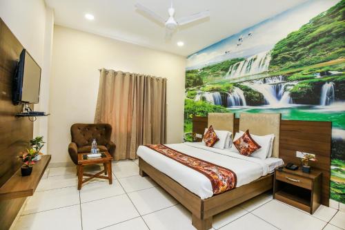 アムリトサルにあるHotel Karan Residency - 5 Min Walk From Golden Templeのベッドと壁に絵が飾られたホテルの部屋