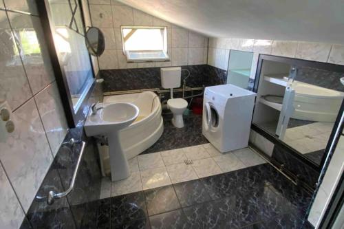 een badkamer met een wastafel, een toilet en een wastafel bij Mirage The Welcome Rest Villa Self Service ! Cazare muncitori Ploiești ! Workers Accommodation ! in Ţînţăreni