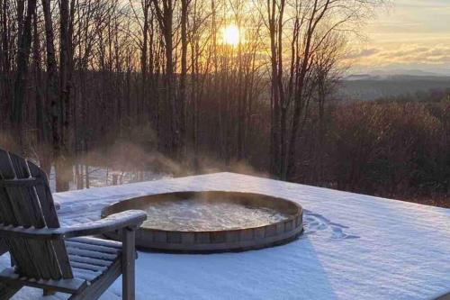 a fire pit in the snow next to a bench at Catskills Barn Apt on 34 acre Estate with Mountain views in Delhi