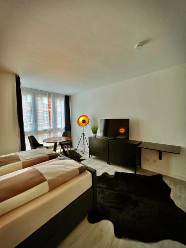 ein Hotelzimmer mit 2 Betten und einem TV in der Unterkunft Talgarten Studio 2 in Erfurt