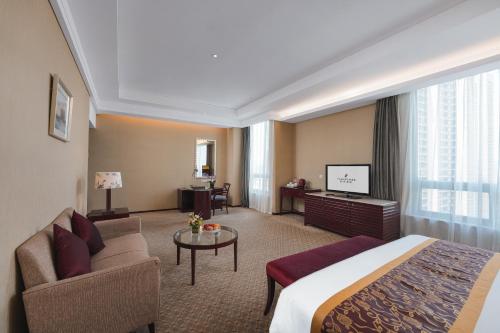 常州市にあるPark Plaza Changzhou, A member of Radisson Hotel&Resortsのベッド、ソファ、テレビが備わるホテルルームです。