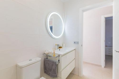 uma casa de banho branca com um lavatório e um espelho em Central Los Gigantes Florida Apt by Dream Homes Tenerife em Acantilado de los Gigantes