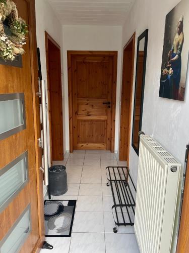 a hallway with a wooden door and a tile floor at Ferienwohnung in der Vulkaneifel "Opp der Holl" in Brockscheid
