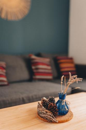 a blue vase with pine cones on a table at In2theRooms Giovanni in Punat