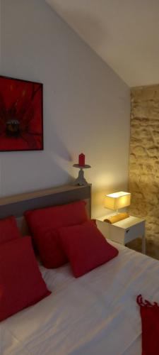 a bedroom with a large bed with red pillows at Gîte Rouge Calme et Nature in Allas-Bocage