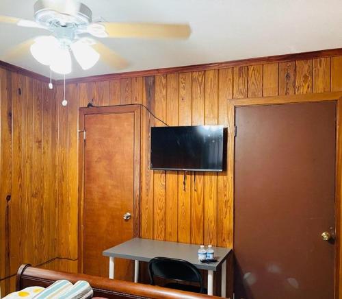 a room with a table and a television on the wall at Terrace Guest House in Tampa