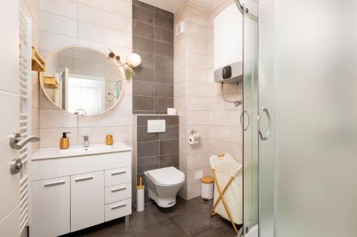 bagno con servizi igienici, lavandino e specchio di In2theRooms a Punat