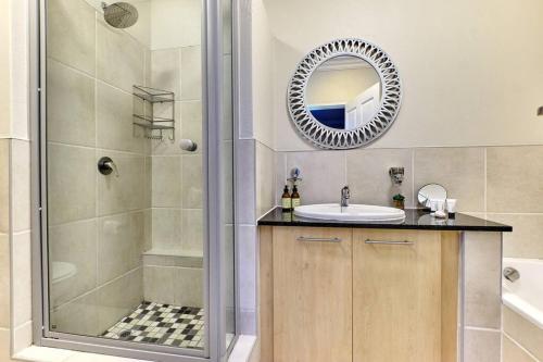 a bathroom with a shower and a sink and a mirror at Westpoint Executive Suites, Sandton, Johannesburg in Johannesburg