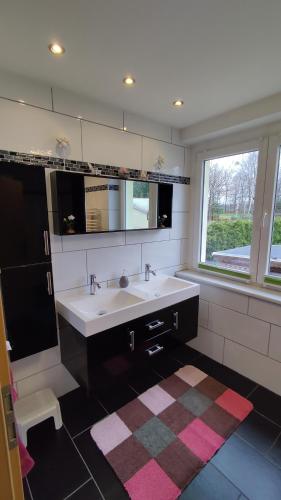 La salle de bains est pourvue d'un lavabo blanc et d'une fenêtre. dans l'établissement Ferienhaus Meier, à Struppen