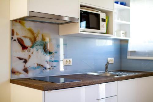 cocina con fregadero y microondas en Apartment Palm View II, en Rovinj