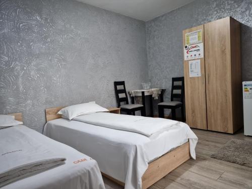a bedroom with two beds and a table and chairs at Casa Lipianu in Târgu Jiu