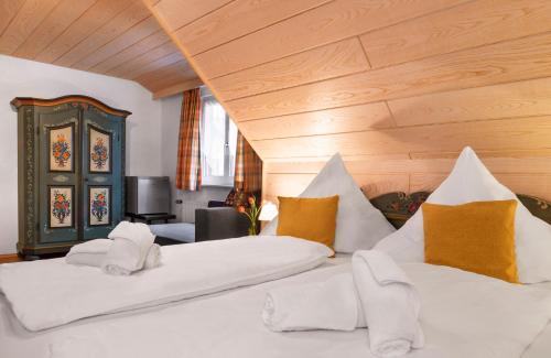 a bedroom with two beds with white and yellow pillows at Hotel Sonnenstube Hagnau in Hagnau