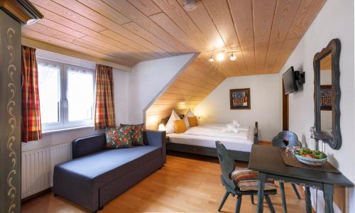 a hotel room with a bed and a couch and a table at Hotel Sonnenstube Hagnau in Hagnau