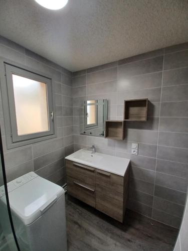 La salle de bains est pourvue d'un lavabo, de toilettes et d'un miroir. dans l'établissement Les Sorbiers - Grand T4 ensoleillé avec Vue Panoramique, à Font-Romeu-Odeillo-Via