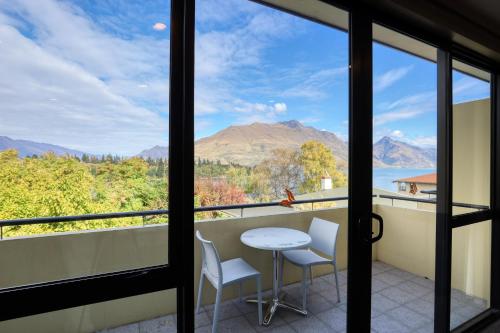 a view from the balcony of a house with a table and chairs at Garden Court Suites & Apartments in Queenstown