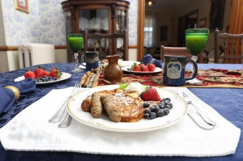 a table with a plate of food and fruit on it at Beauclaires Bed & Breakfast in Cape May