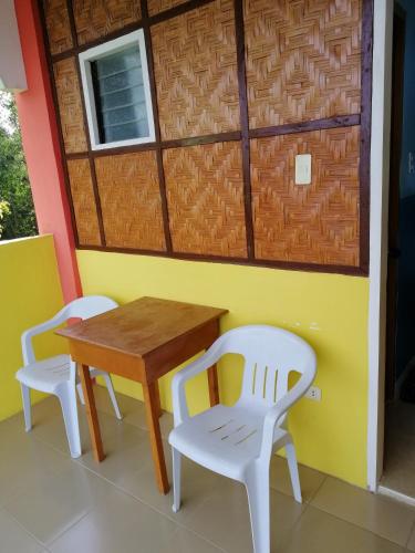 una mesa y dos sillas y una mesa y una puerta en ISLET VIEW Pension House ( Formerly Island View Pension House ), en Oslob