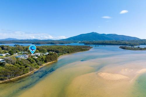 an aerial view of a beach with a sign in the water at Lake View Luxury Wallaga Lake - 21 Lakeview Drive in Tilba Tilba