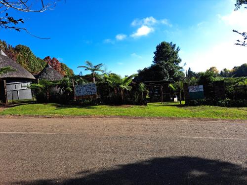 an empty street with a house and a tree at Horizon View Chalets in Graskop