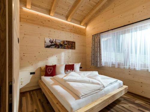 een slaapkamer met een bed in een houten kamer bij Alpenchalets Oberlaiming in Itter