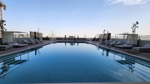 a large swimming pool with lounge chairs on a building at STAY BY LATINEM Luxury 1BR Holiday Home CVR A3002 near Burj Khalifa in Dubai