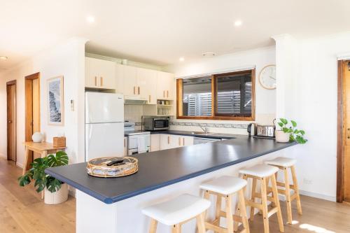 a kitchen with a large black counter and stools at Torquay Hotel/Motel in Torquay