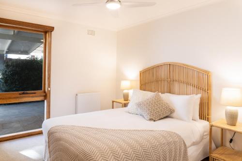 a bedroom with a bed with white sheets and a window at Torquay Hotel/Motel in Torquay