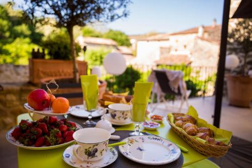 uma mesa com pratos e taças de fruta em LES CENT CIELS em Salavas