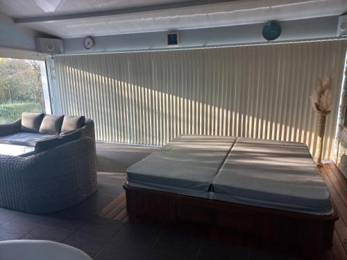 a room with a bed and a couch and a window at Charmante maison avec spa, sauna et jardin privatif in Saint-Gervais