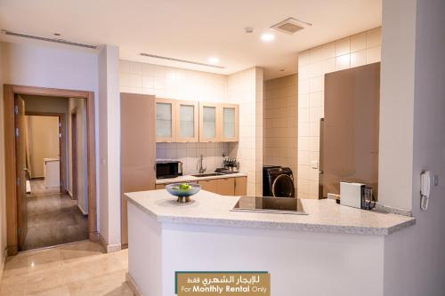 a large kitchen with a counter top in a room at Mabaat - Obhour - 358 in Jeddah