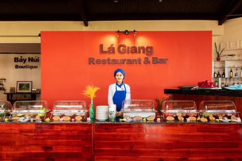 a woman standing in front of a sign with food at Victoria Nui Sam Lodge in Chau Doc