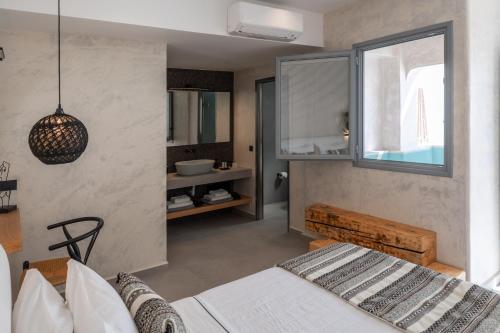 a bedroom with a bed and a sink in a room at Almyra Oia Suites in Oia