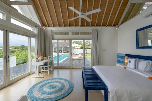 a bedroom with a large bed with a ceiling fan at Casa del Mar in Nusa Lembongan