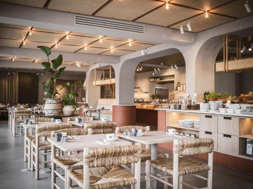 ein Restaurant mit Tischen und Stühlen und eine Küche in der Unterkunft Strandhotel Domburg in Domburg