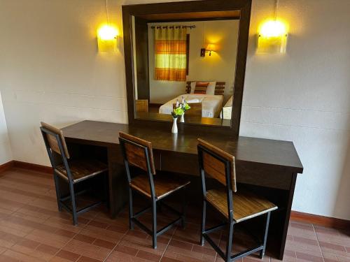 a dining room with a table and chairs and a mirror at Soft Resort Kad Farang Hangdong in Ban Yang Plao