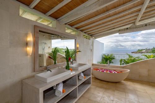a bathroom with two sinks and a large mirror at Casa del Mar in Nusa Lembongan