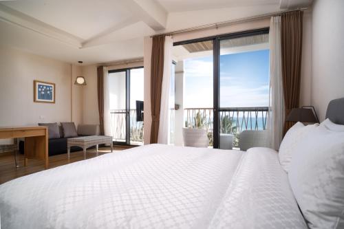 a bedroom with a bed and a view of the ocean at 畫日風尚會館Sinasera Resort in Changbin