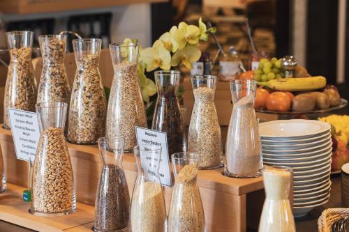 a table with several glass vases filled with food at Hotel Tanneck in Bad Wörishofen