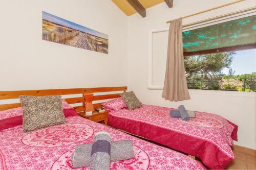 a bedroom with two beds and a window at Buena Ventura Villa in Cala en Bosc